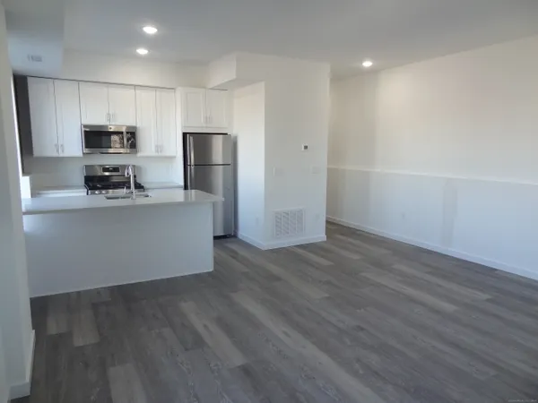 a kitchen with stainless steel appliances a refrigerator and a stove top oven