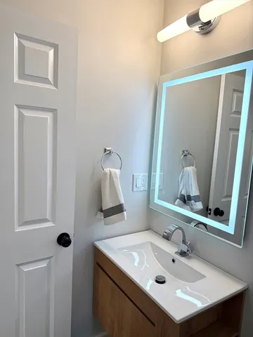 a bathroom with a sink vanity and mirror
