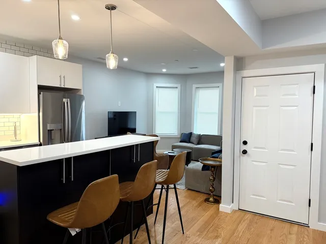 a kitchen with a table chairs refrigerator and microwave