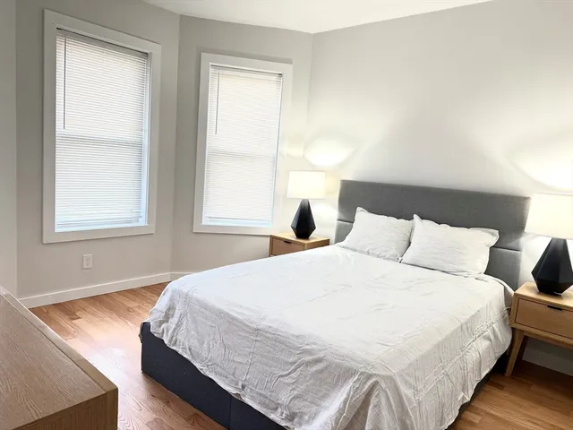 a large bed sitting in a bedroom next to a window