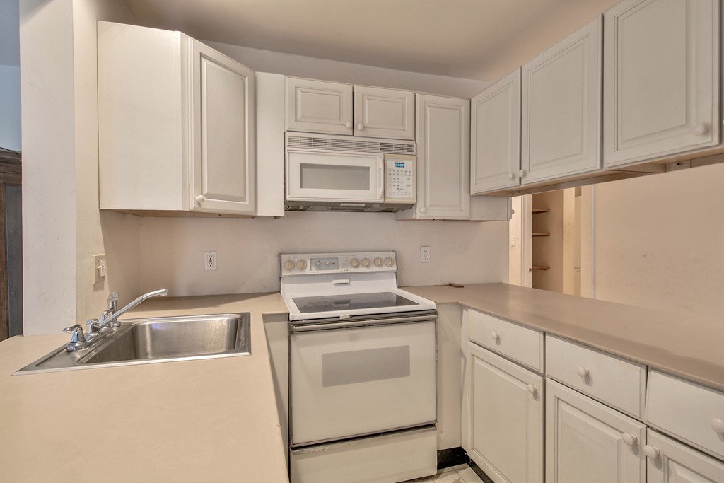 21 Bennett Street Manchester, MA 01944 - Photo 11 of 17 a kitchen with white cabinets and white appliances