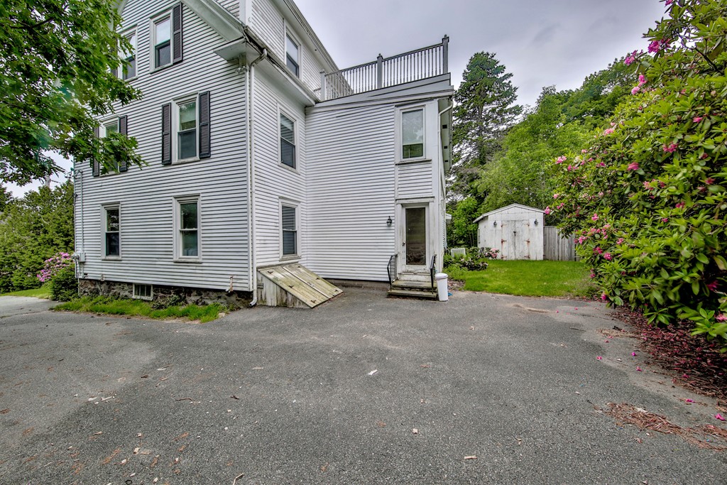 21 Bennett Street Manchester, MA 01944 - Photo 3 of 17 a view of a house with a yard and garage