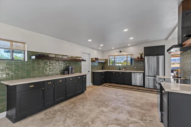 a kitchen with stainless steel appliances kitchen island granite countertop a refrigerator and a stove top oven