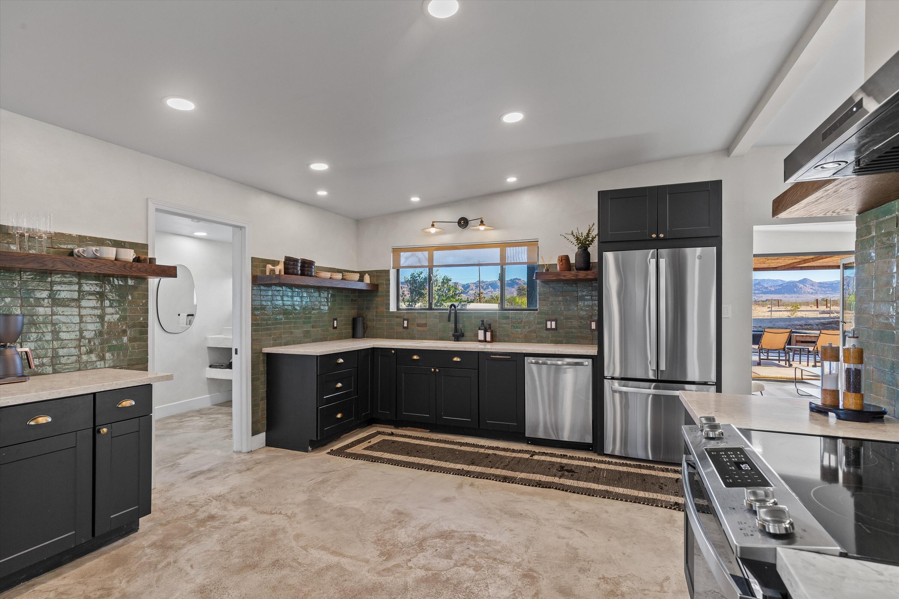 4610 Sunkist Road Joshua Tree, CA 92252 - Photo 19 of 55 a kitchen with stainless steel appliances kitchen island granite countertop a refrigerator and a stove top oven