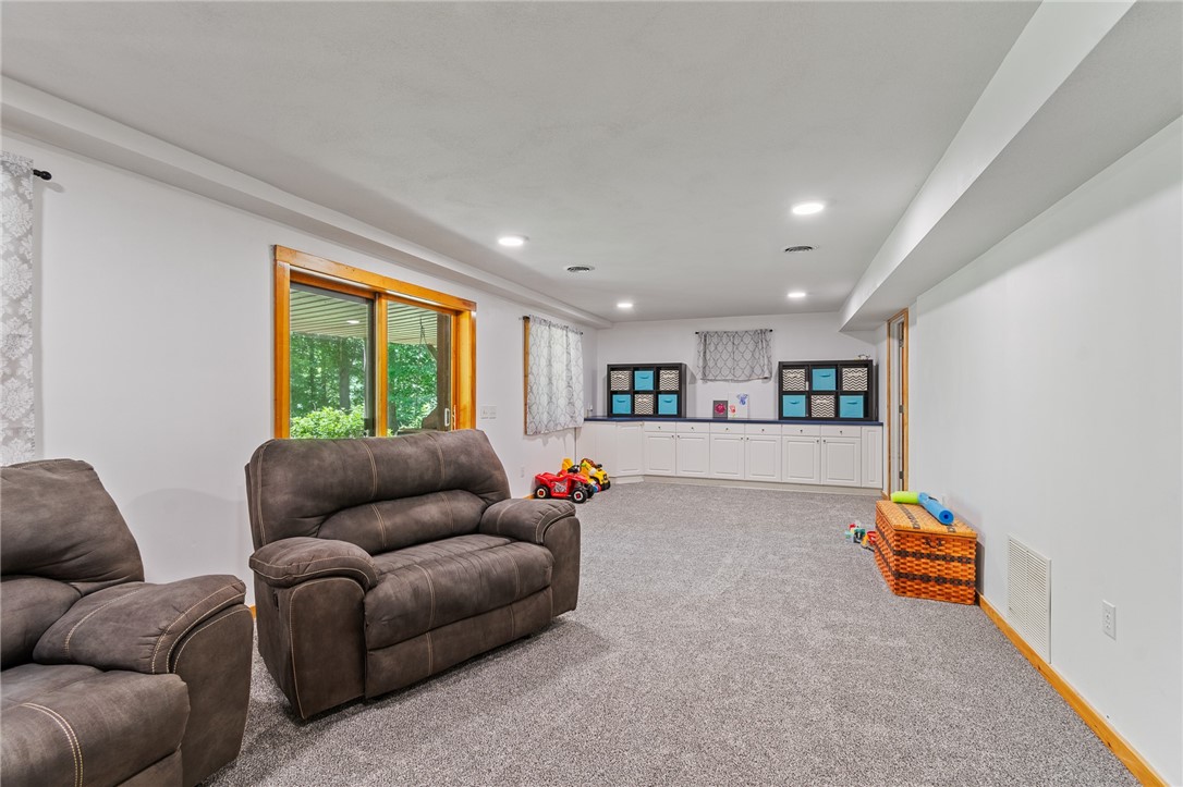 7733 East Port Bay Road Wolcott, NY 14590 - Photo 25 of 49 The finished lower level is a walk out to the covered patio area and beautiful views of the bay! New carpet and LVT flooring!