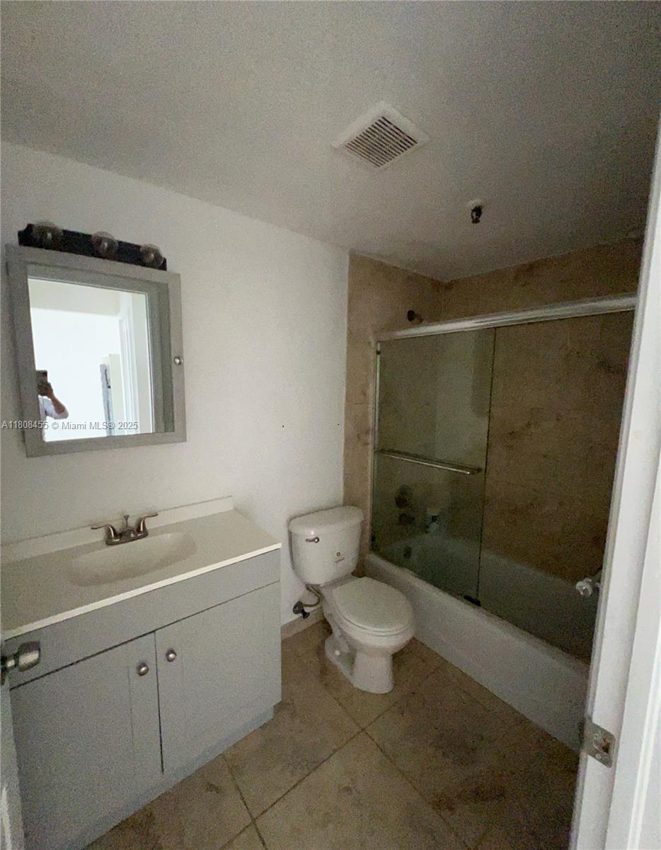 677 Northeast 24th Street, Unit 607 Miami, FL 33137 - Photo 24 of 29 a bathroom with a toilet sink vanity and mirror