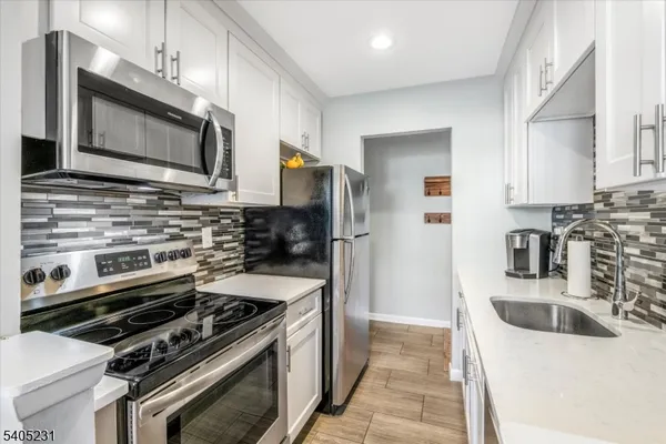 a kitchen with a sink stainless steel appliances and cabinets