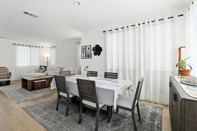 a kitchen with stainless steel appliances kitchen island granite countertop a stove a sink a dining table and chairs