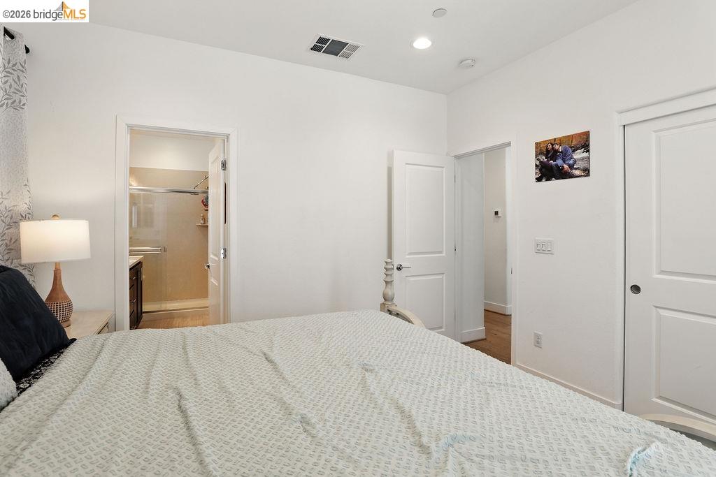 863 Lookout Street Richmond, CA 94804 - Photo 21 of 42 Bedroom with recessed lighting, connected bathroom, and wood finished floors