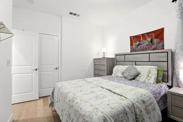 a bedroom with a large bed and a painting on the wall