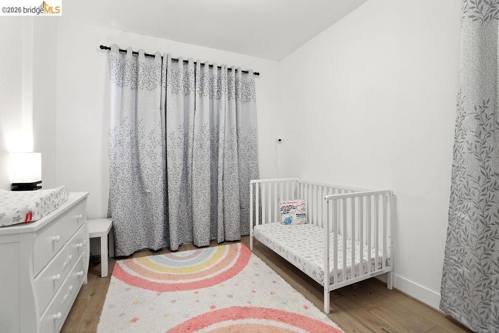 863 Lookout Street Richmond, CA 94804 - Photo 30 of 42 Bedroom with wood finished floors and a crib