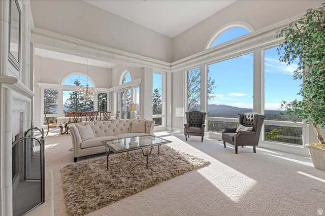 3222 Eagle View Circle Sandy, UT 84092 - Photo 7 of 60 Living room with carpet floors, healthy amount of natural light, a high ceiling, a mountain view, and suspended lighting