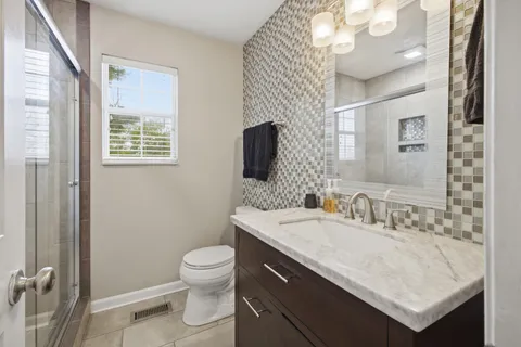 a bathroom with a sink a toilet and a mirror