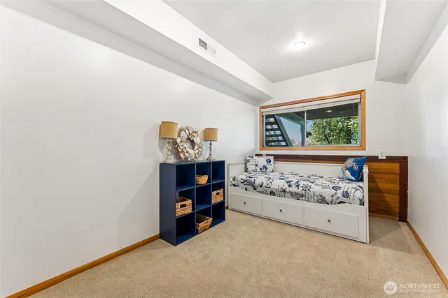 a view of a bedroom with baby bed and window