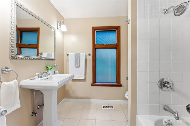 a bathroom with a sink mirror and tub