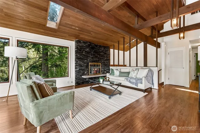 a living room with furniture a flat screen tv and floor to ceiling window