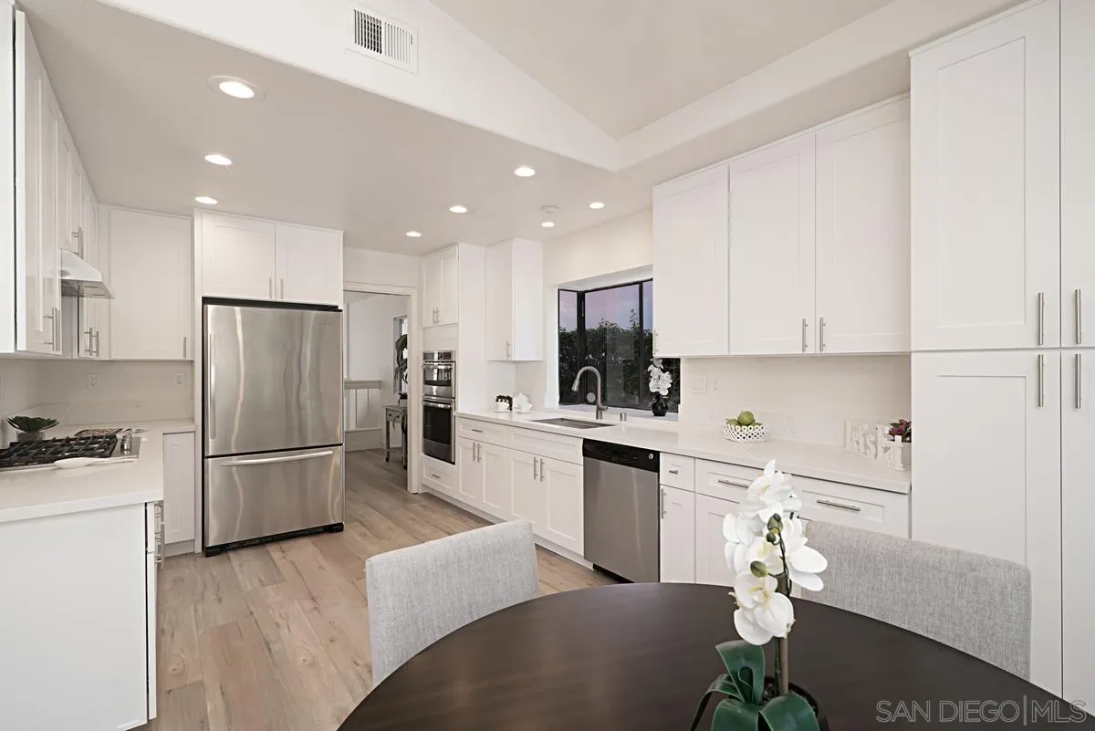 4256 Caminito Terviso San Diego, CA 92122 - Photo 14 of 32 a kitchen with white cabinets and stainless steel appliances
