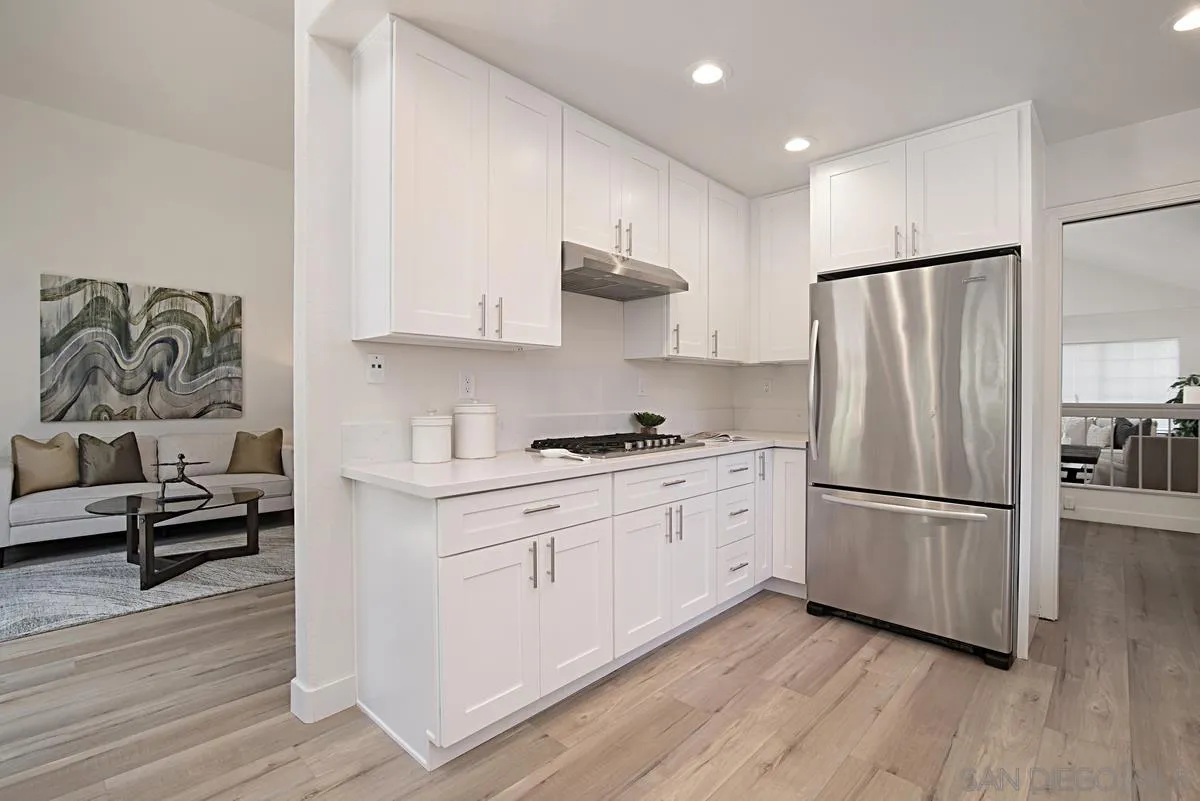 4256 Caminito Terviso San Diego, CA 92122 - Photo 15 of 32 a kitchen with stainless steel appliances granite countertop a refrigerator sink and white cabinets