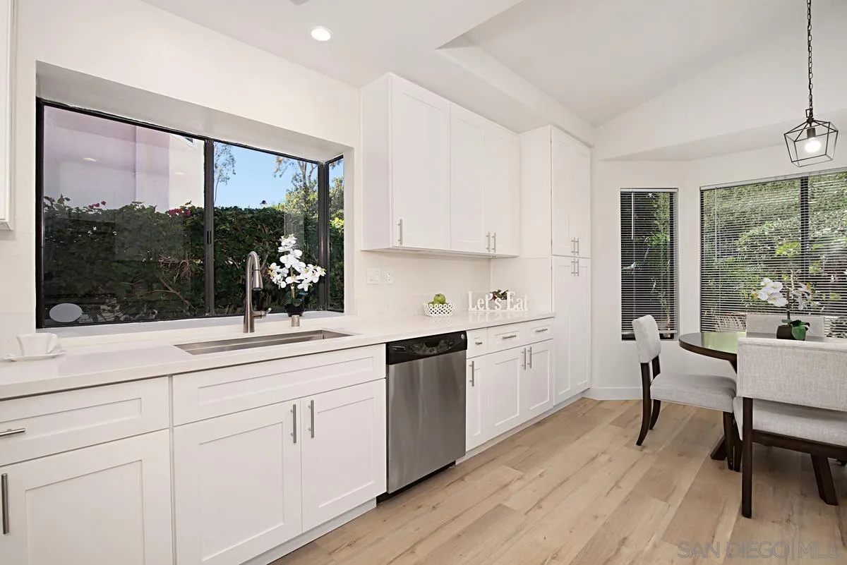 4256 Caminito Terviso San Diego, CA 92122 - Photo 17 of 32 a kitchen with white cabinets and wooden floors