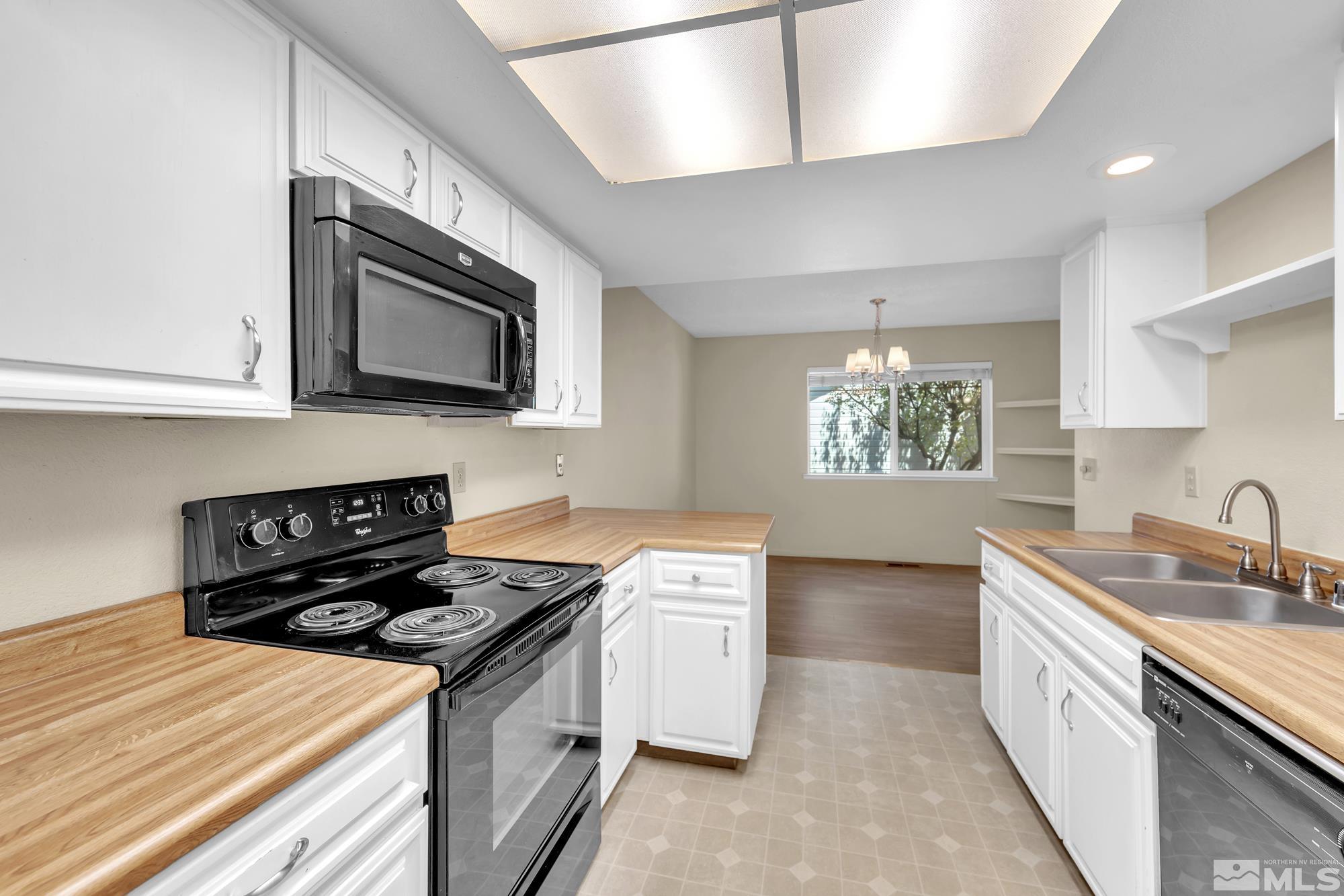 6025 Conness Way Reno, NV 89523 - Photo 10 of 30 a kitchen with stainless steel appliances granite countertop a sink stove and microwave