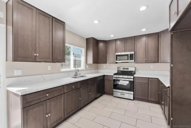 a kitchen with a stove sink and cabinets