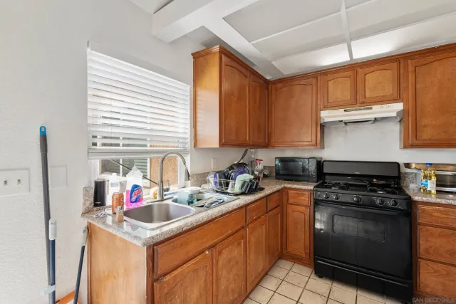 a kitchen with stainless steel appliances granite countertop a refrigerator sink and stove
