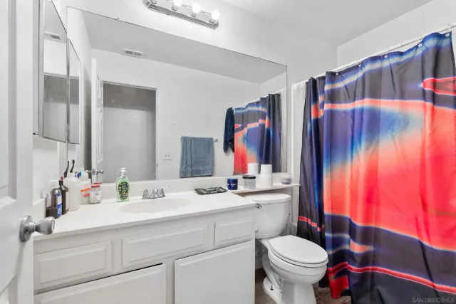 a bedroom with a bed table chair and a window
