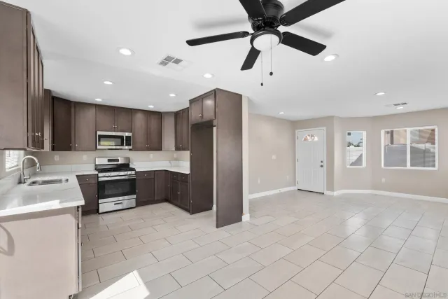 a kitchen with stainless steel appliances granite countertop a sink and dishwasher a stove top oven with wooden floor