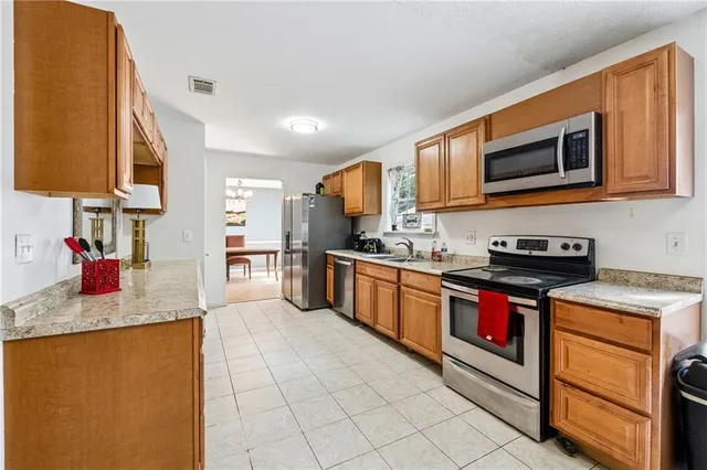 a kitchen with granite countertop stainless steel appliances and wooden cabinets