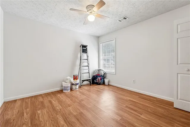 a view of a room with gym equipment and wooden floor