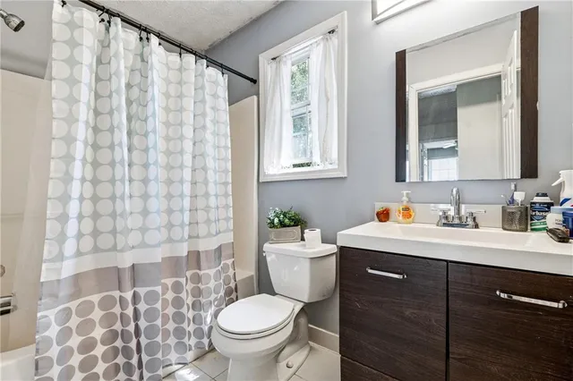 a bathroom with a granite countertop sink toilet and mirror