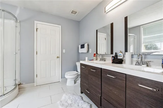 a bathroom with a sink a toilet and a large mirror