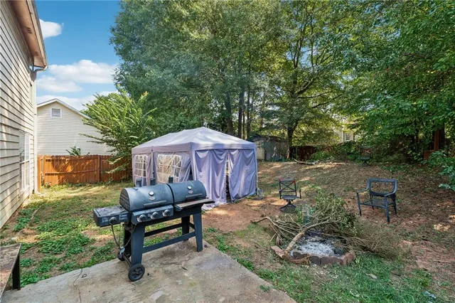a view of a backyard with sitting area furniture and a fire pit
