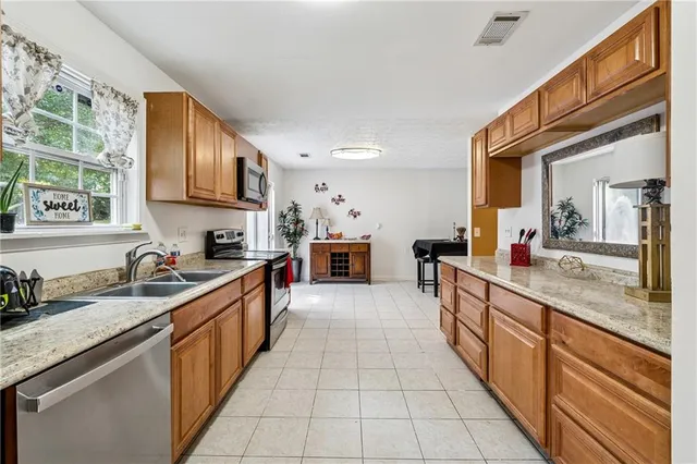 a large kitchen with stainless steel appliances granite countertop a sink and cabinets