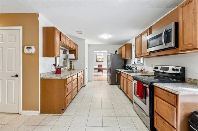 a large kitchen with stainless steel appliances granite countertop a large stove a sink dishwasher and cabinets
