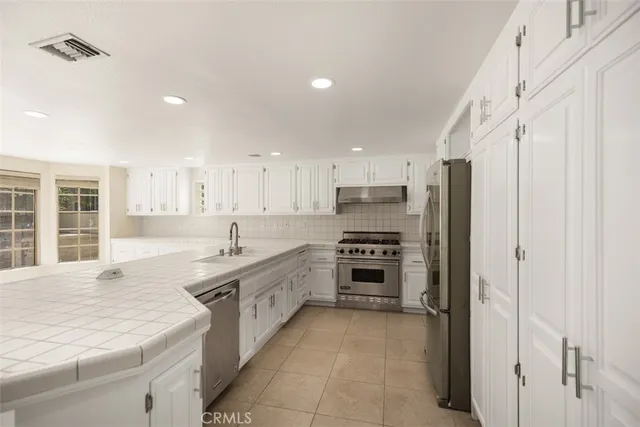a large kitchen with stainless steel appliances lots of counter top space and cabinets