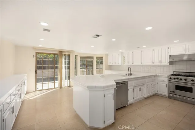 a large kitchen with stainless steel appliances granite countertop a stove top oven sink and cabinets