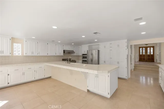a large white kitchen with cabinets