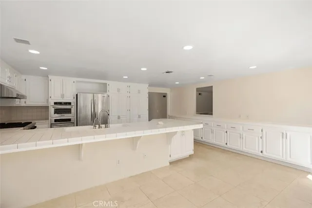 a large white kitchen with stainless steel appliances