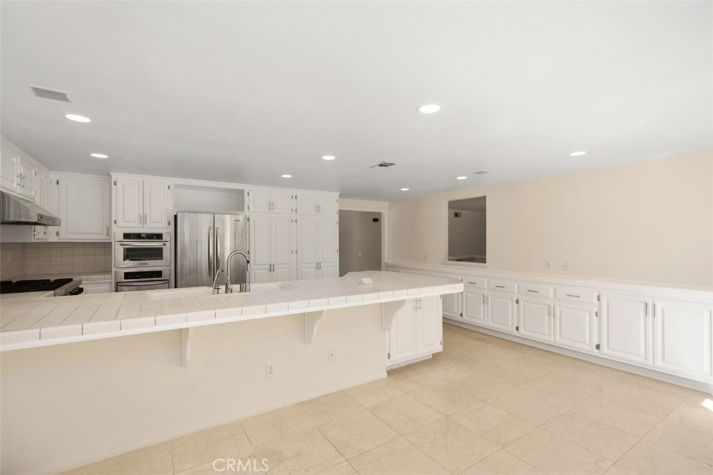 21322 Calle Balsa Lake Forest, CA 92630 - Photo 19 of 45 a large white kitchen with stainless steel appliances