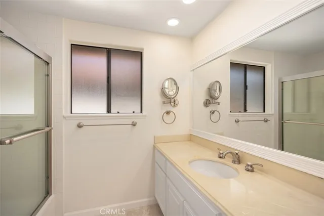 a bathroom with a tub a sink and mirror
