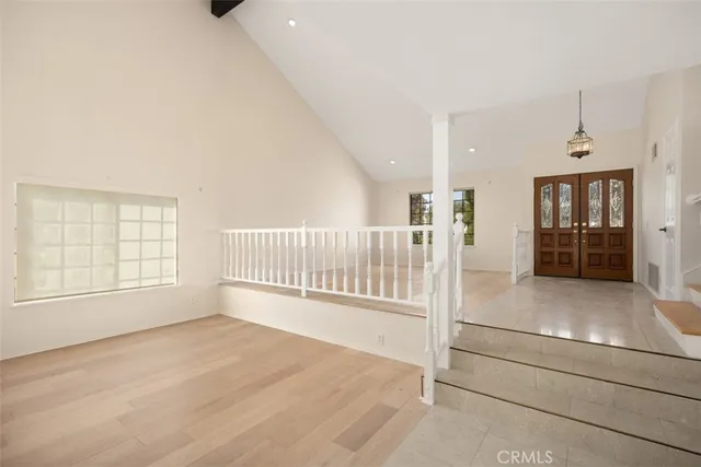 an entryway with wooden floor and windows