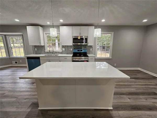 a kitchen with kitchen island a stove a sink and a refrigerator