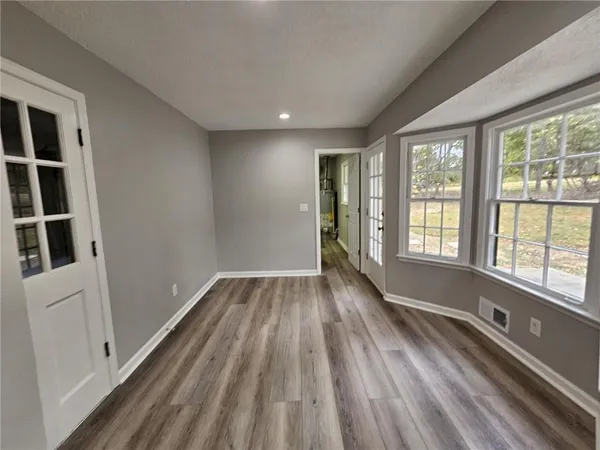 a view of hallway with windows and wooden floor