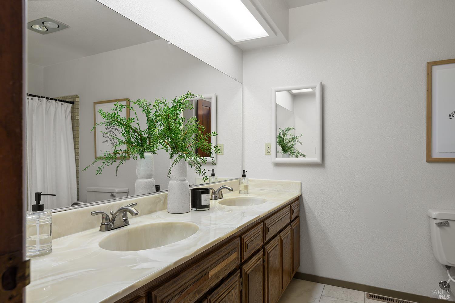 7595 Giusti Road Forestville, CA 95436 - Photo 21 of 41 a bathroom with a double vanity sink and a mirror