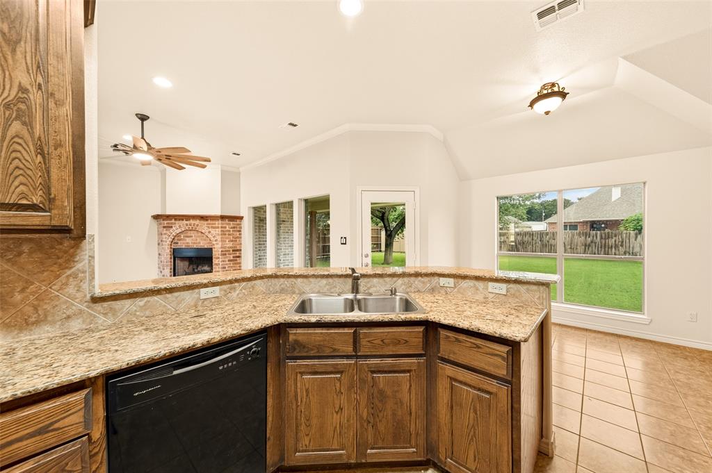 2105 Ridgewood Drive Bridgeport, TX 76426 - Photo 13 of 27 Kitchen featuring a double basin sink, granite-style countertops, and wood-finish cabinetry
