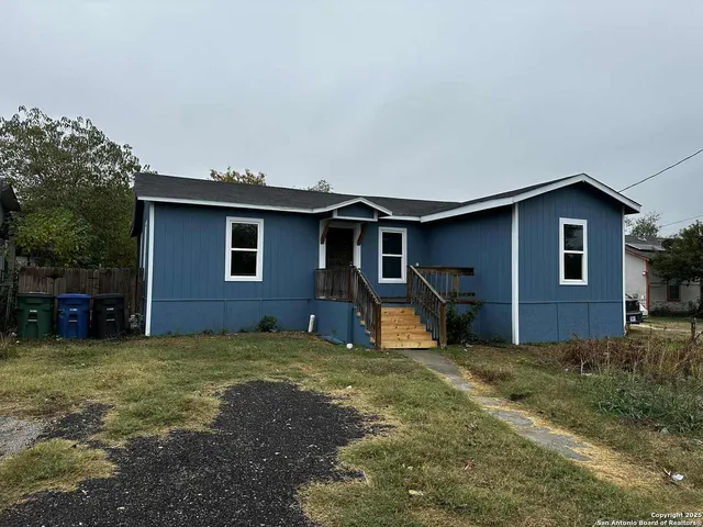 a view of a house with yard and chairs in patio