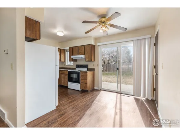 a open kitchen with a refrigerator a stove top oven a sink and dishwasher with wooden floor