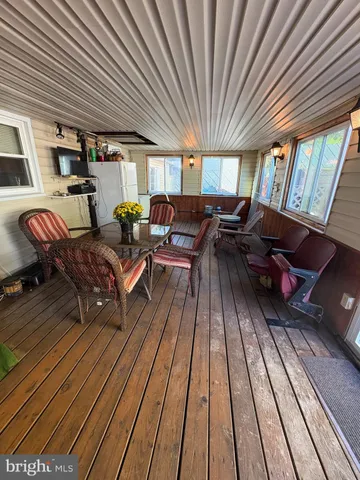 a living room with a dining table chairs and a refrigerator