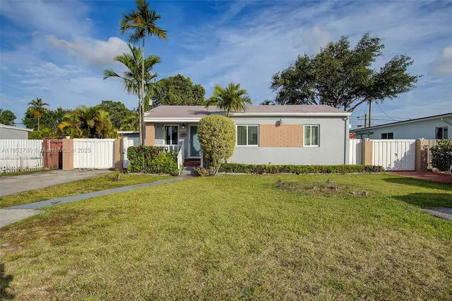 a front view of house with yard and trees